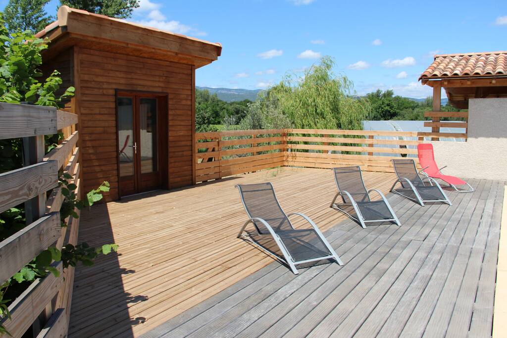 vaste plage en bois avec cabanon pour détente et jeux enfants