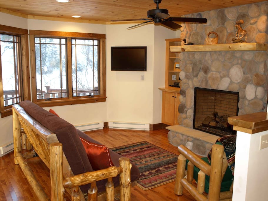 Main level sitting area with river rock fireplace & TV