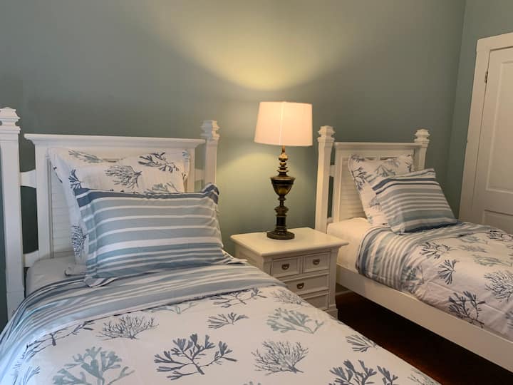 The Egret
The Egret sleeps two in this relaxing bedroom with two twin sized beds. This room has ample storage space with a small closet, luggage rack and an armoire. There is also a dedicated work space.