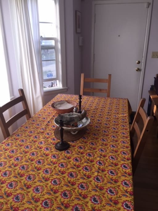 Dining table with sunny bay windows. Seats eight comfortably.