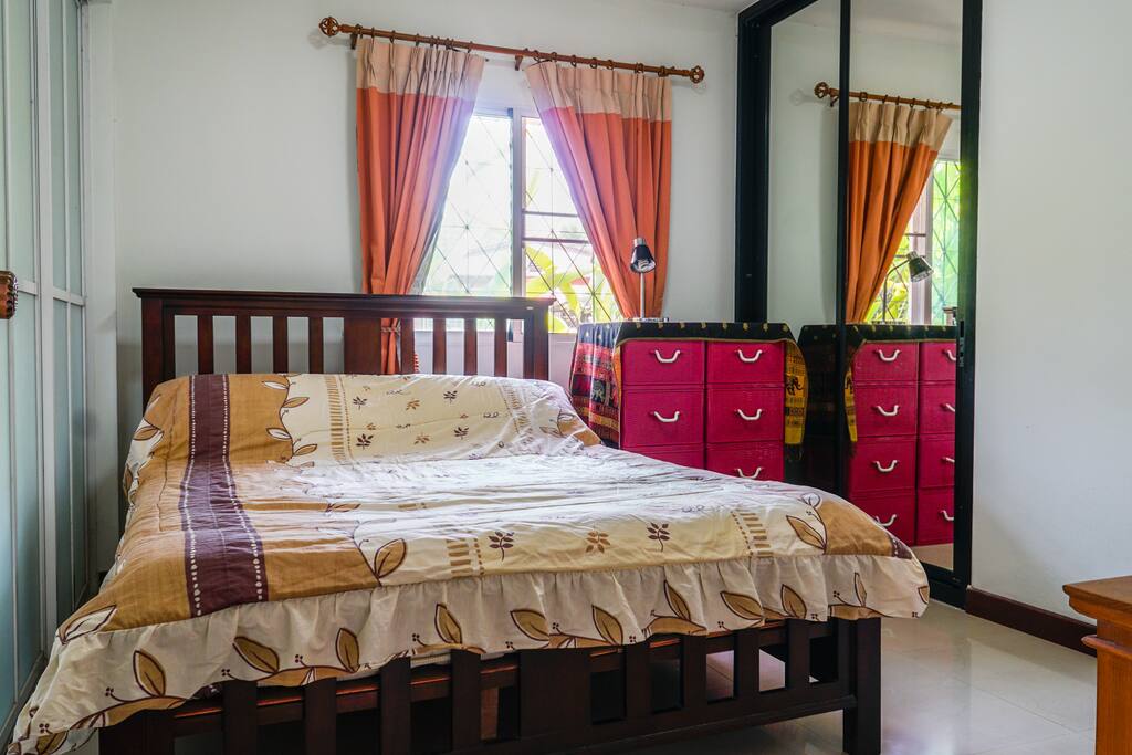 The main bedroom has a large bed, bathroom with hot water, and a TV with local channels.