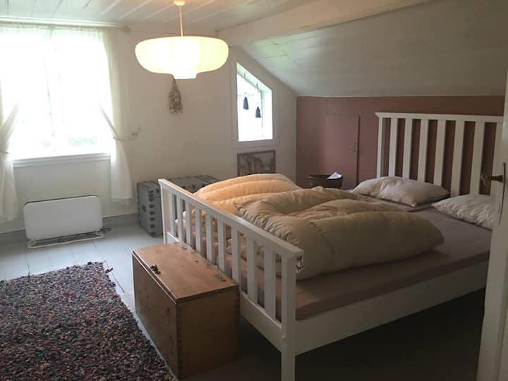 Spálňa na druhom poschodí: Storetinden.  Pani je viditeľná z okna, v diaľke.  Je 1408 metrov vysoký a z centra mesta sa zdá byť dobrý.