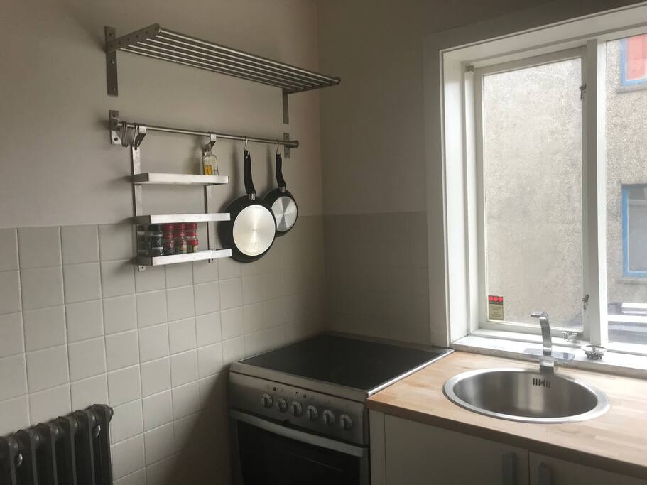 The kitchen has an electric stove that is attached to the oven.