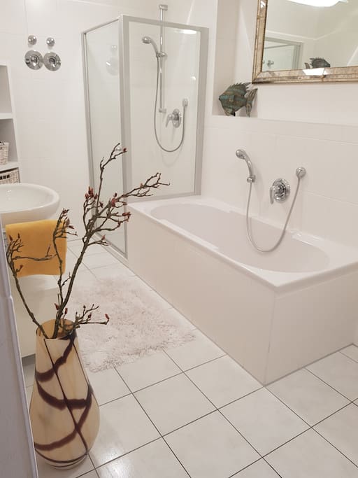 Badezimmer mit Badewanne und Echtglasduschkabine