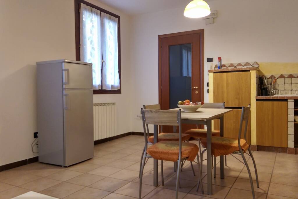 Soggiorno con angolo cottura e camino - Living room with kitchen and fireplace