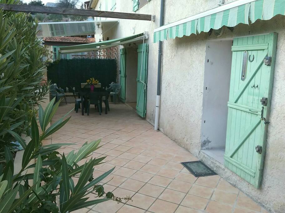 Grande terrasse avec la porte fenêtre de la cuisine et la baie vitrée du salon