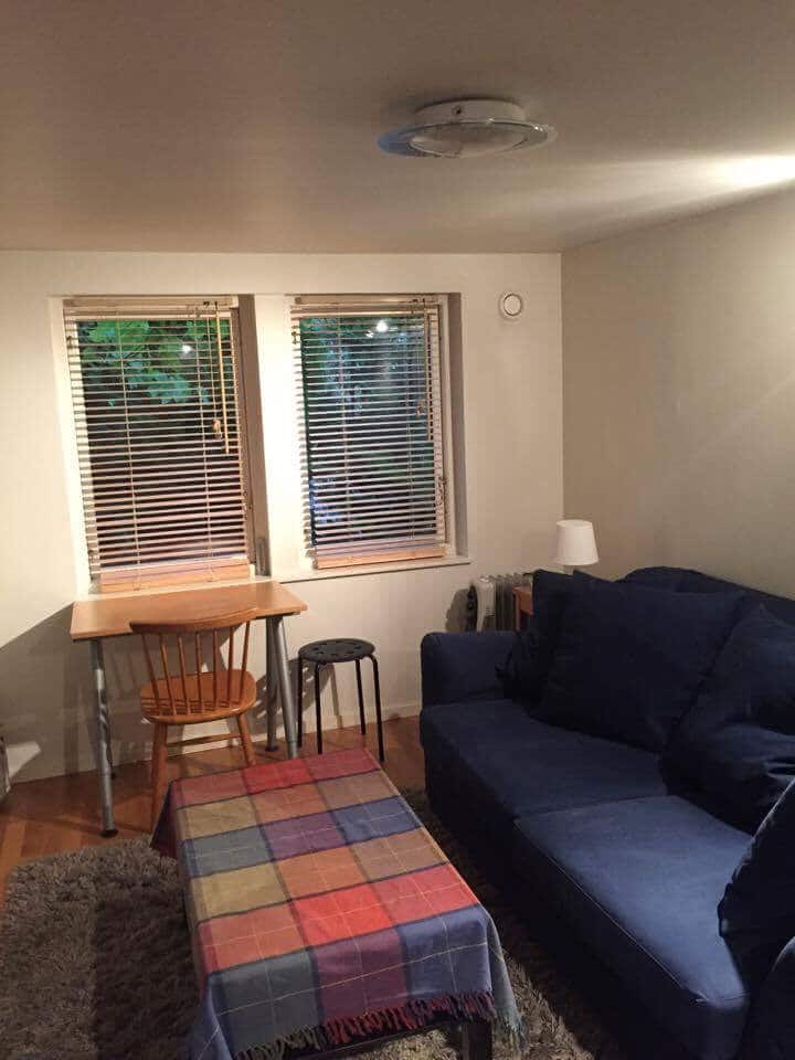 Pequeña sala de estar con mesa y sofá cama.