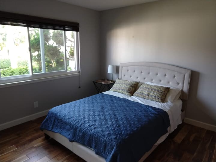 客房间配备标准双人床，可俯瞰绿色空间和游泳池。