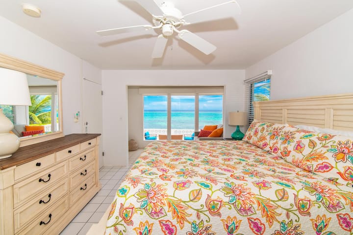 Une autre chambre spacieuse avec un lit king size, de belles vues sur l'océan et un ventilateur de plafond. La décoration minimaliste et la literie confortable rendent cette pièce à la fois élégante et reposante.