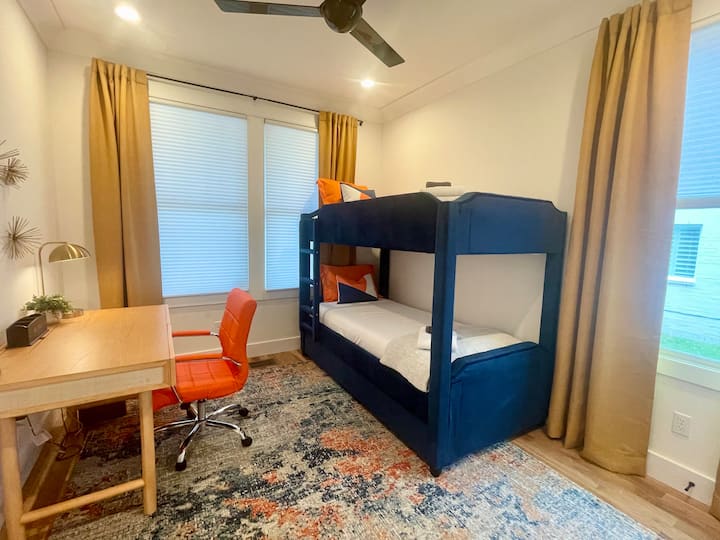 Chumba hiki chenye mwangaza kina sehemu ya kufanyia kazi na kitanda cha watu wawili.