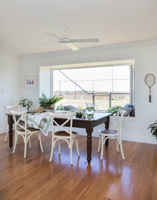 Large dining table with oversized bench seat to dine at or take in the wide open spaces or watch a game of tennis.