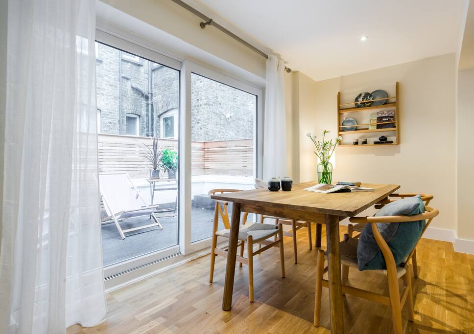 The dining area is in front of the doors leading out onto the private terrace.