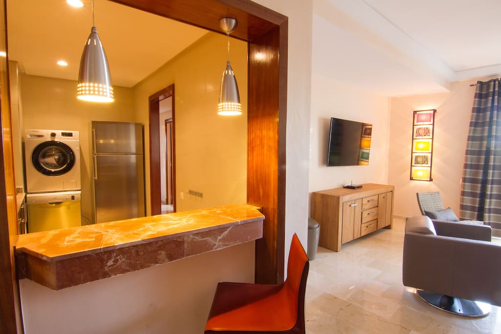 Entée dans l' appartement cuisine entièrement équipée (four, frigo, micro onde, machine a laver, lave vaisselle) vue sur salon et salle a manger.