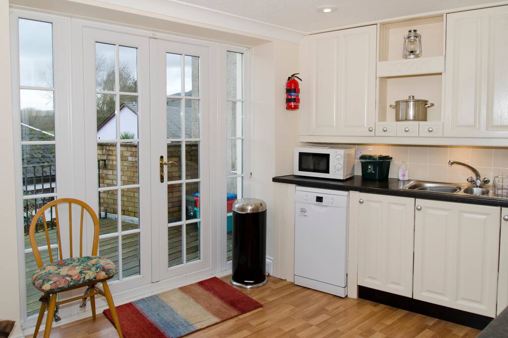 Patio doors open onto decking with fabulous views of Crug Hywel