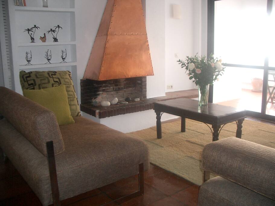 Lounge with copper fire place ,adjonining dinning area, and terrace with sea views
