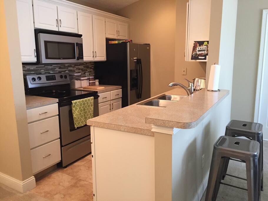 Recently remodeled kitchen with gorgeous tile backsplash and stainless steel appliances.