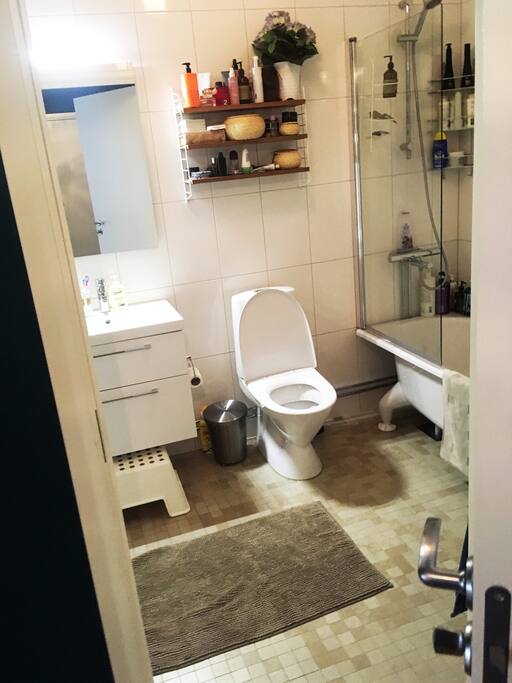 Badrum med badkar, toalett, tvättmaskin och torktumlare