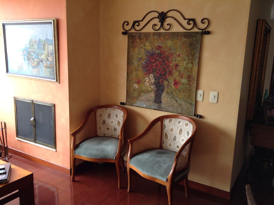 Dos sillas y un cuadro de la sala. A la izquierda, la chimenea.