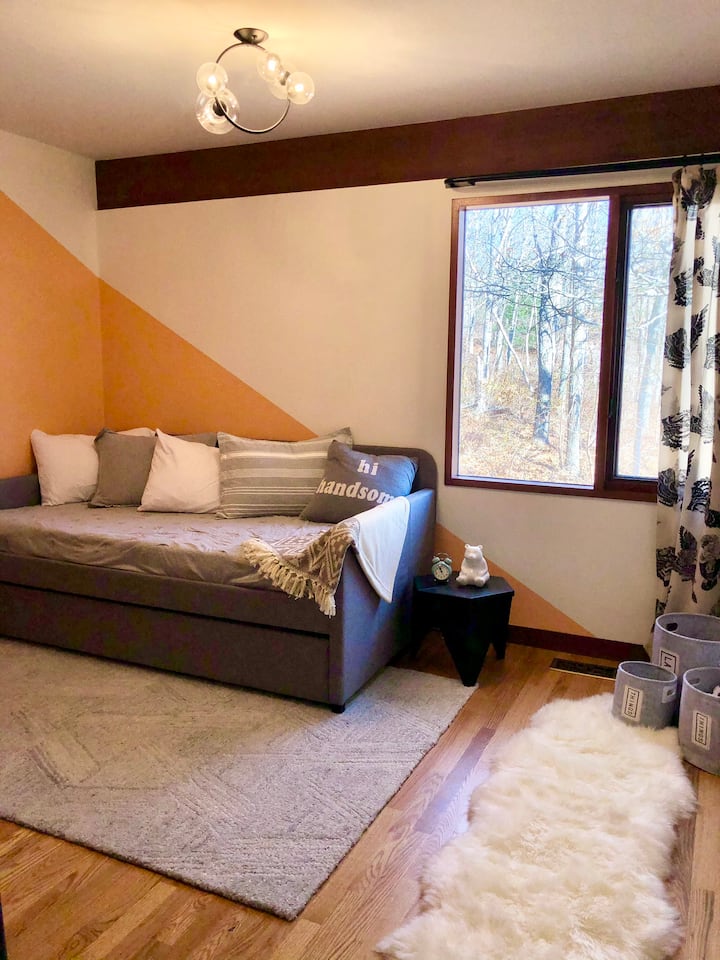 Schattige kinderkamer met een uitschuifbed met 2 grote eenpersoonsbedden. 