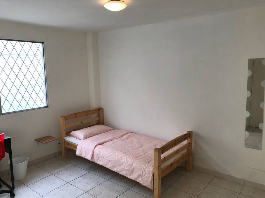 Habitación individual con escritorio y espejo