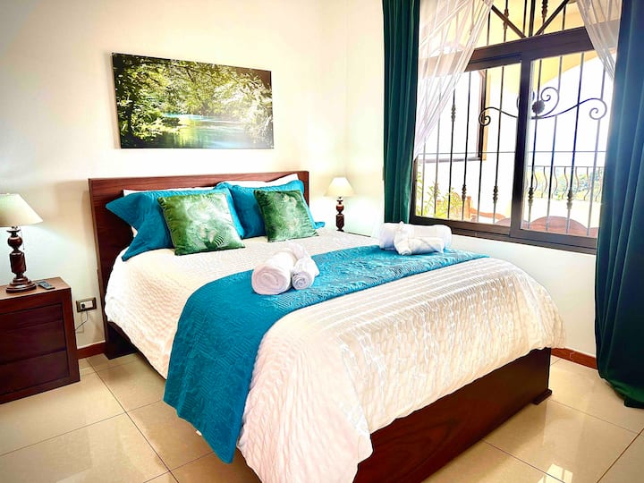 Beautiful upstairs bedroom #4 with a wall AC unit, queen bed, a smart TV, an armoire, and large window with amazing views.