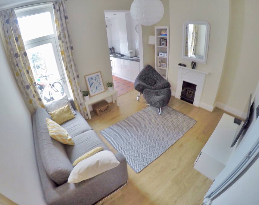 View of living room as you walk in through the hallway, the kitchen is adjoining