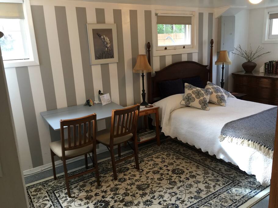 The bedroom with table, chairs, dresser and double bed is down the stairs