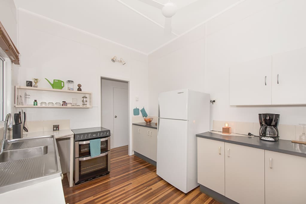 Large fridge/freezer, coffee percolator and new oven with cooktop.