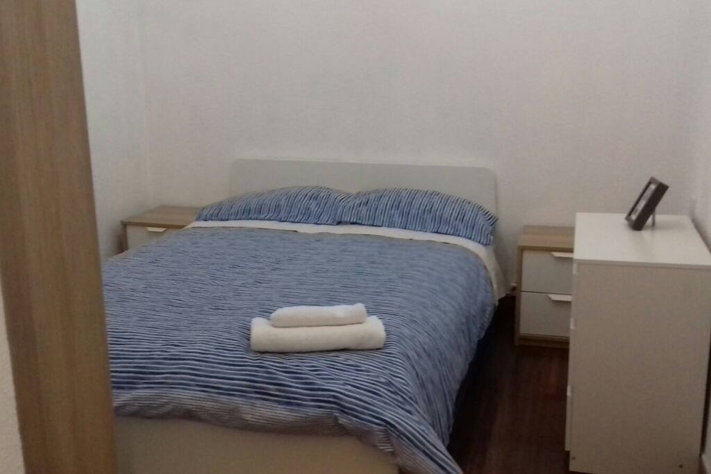 cama de matrimonio y armario con una comoda de 3 cajones