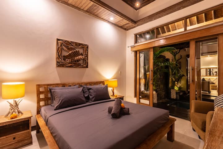 Amplio dormitorio con una gran cama tamaño king, sábanas de felpa y una gran puerta corredera de fácil acceso a la piscina.
