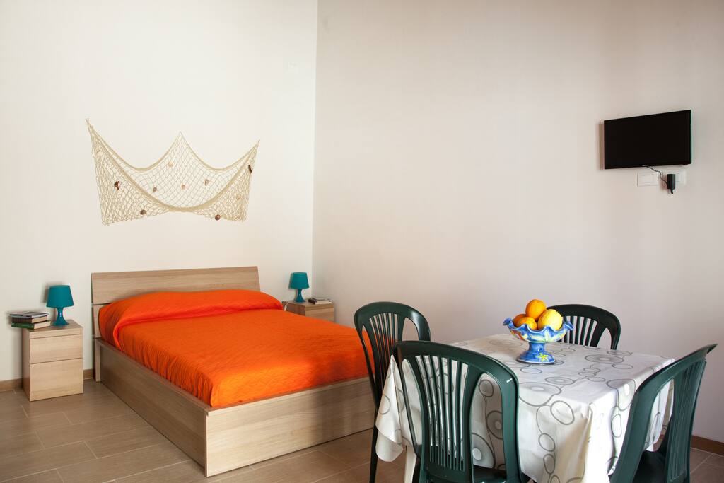 letto con comodini e TV led