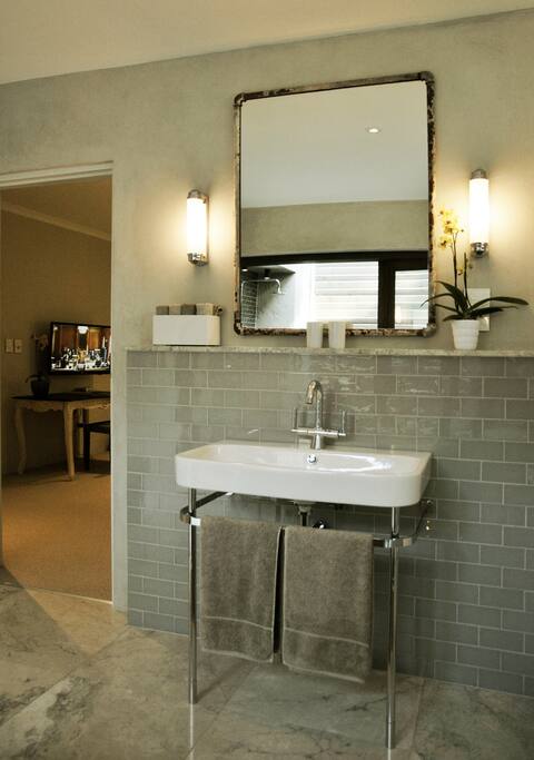 Freestanding basin and glass tiles offer a luxurious stay.