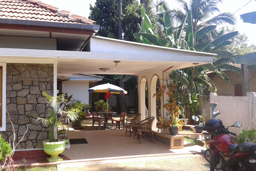 front porch has sun umbrella and table and chairs