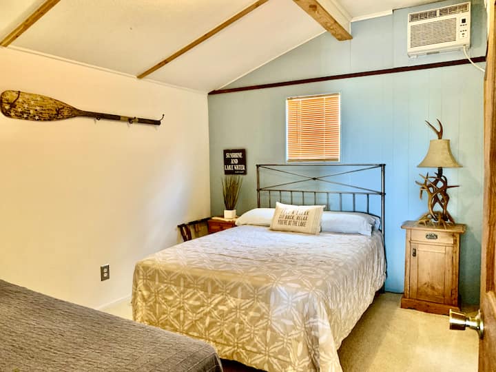 El primer dormitorio con cama de tamaño completo y dos camas individuales.
