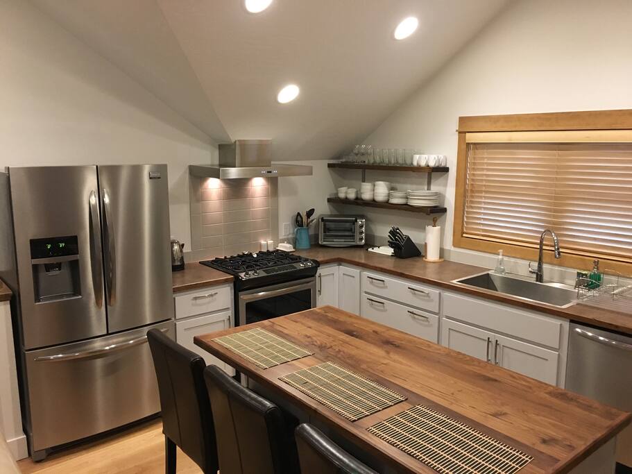 Modern Kitchen with all appliances, utensils, cooking pots, pans, dishes and everything needed to dine in.