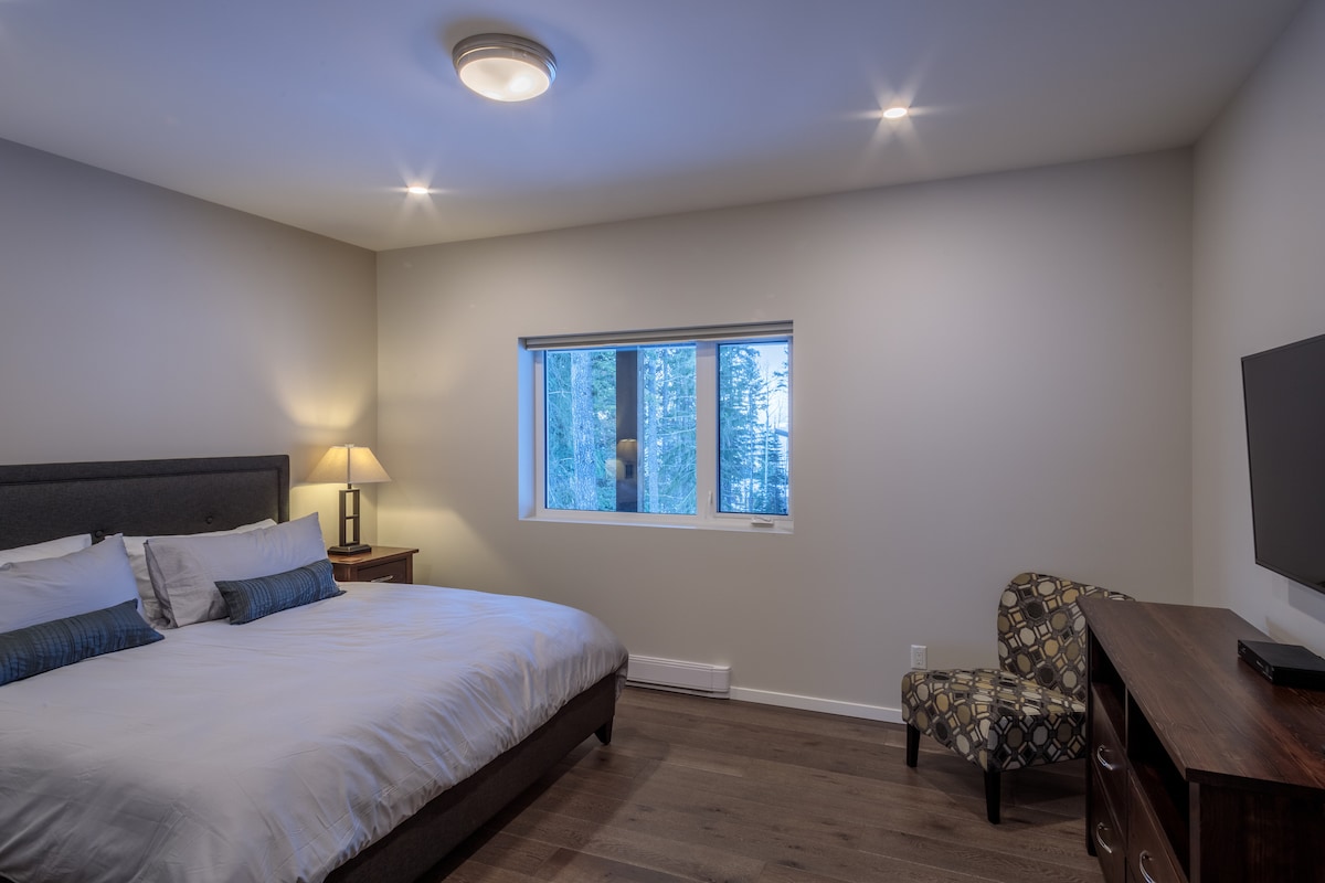 חדר שינה ראשי ענק עם מיטת קינג סייז, חדר ארונות גדול, שולחנות צד, טלוויזיה בלוויין, נגן Blu - Ray ונוף מעולה לחלון.