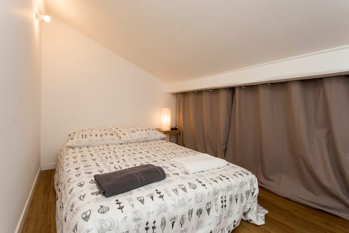 Chambre sous toit avec lit double et climatiseur.