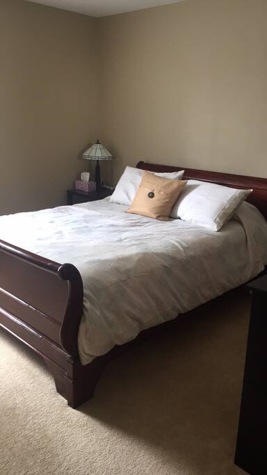 Queen sized sleigh bed, easy access to outlet on bedside table.