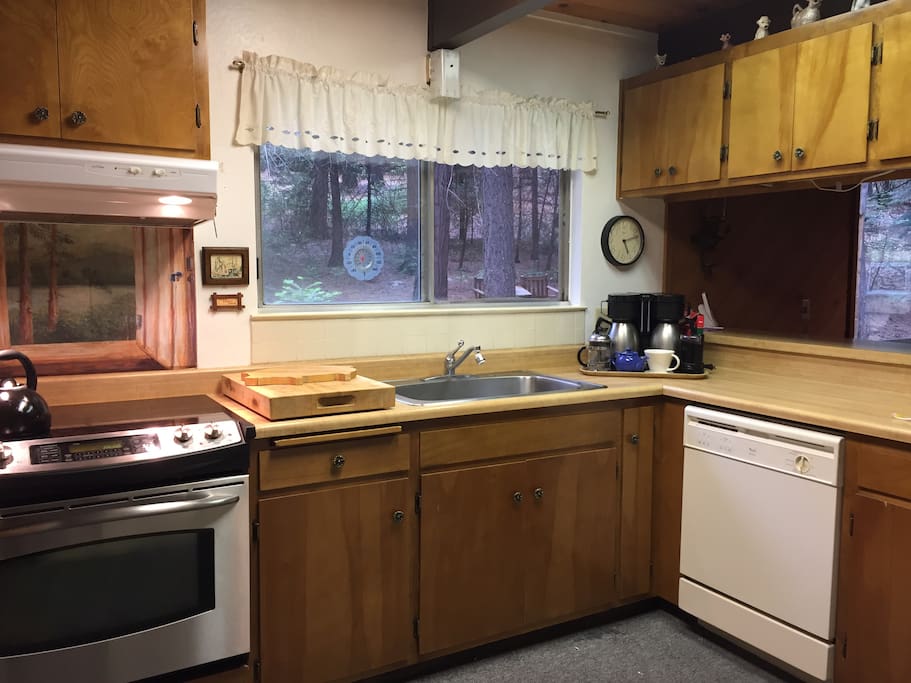 Fully equipped kitchen with dishwasher, stove, oven, refrigerator, blender, food processor, and coffee station.