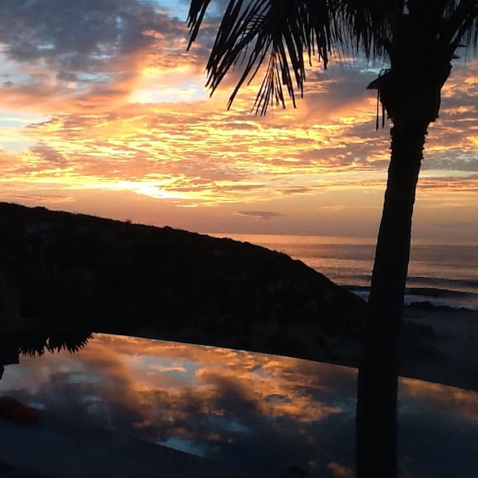 Good Morning View across the pool to sunrise on the ocean .