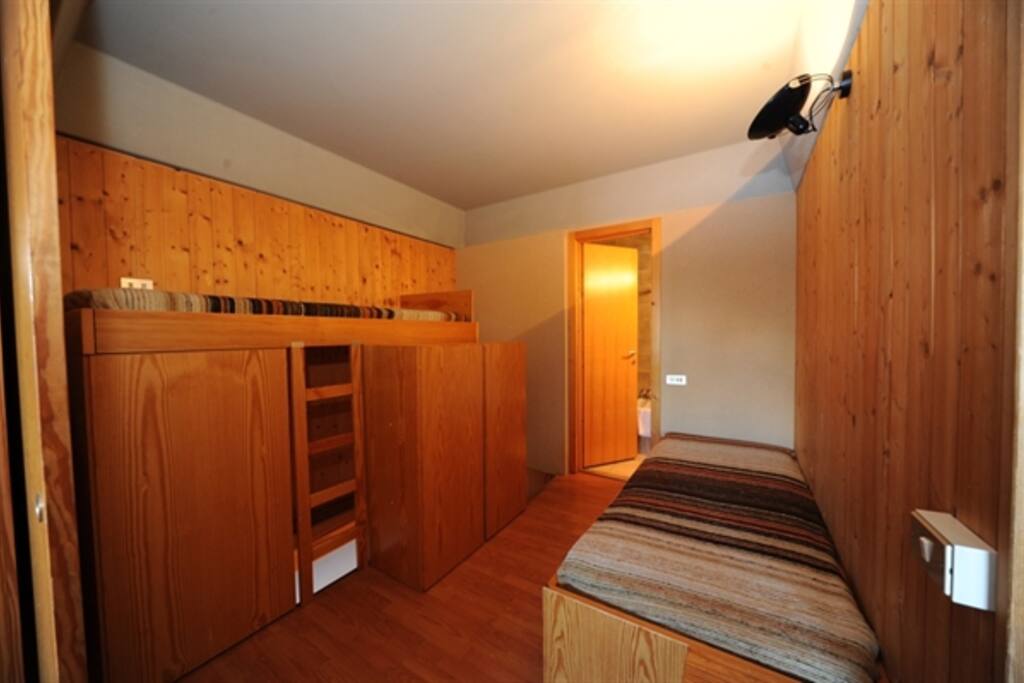 vano al piano superiore con due posti letto e armadi e porta di accesso al bagno