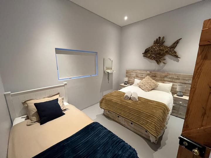 Cama de matrimonio con cama individual adicional y cama individual extraíble. La habitación puede alojar cómodamente a 2 adultos y 2 niños. Tiene baño propio con bañera y ducha.