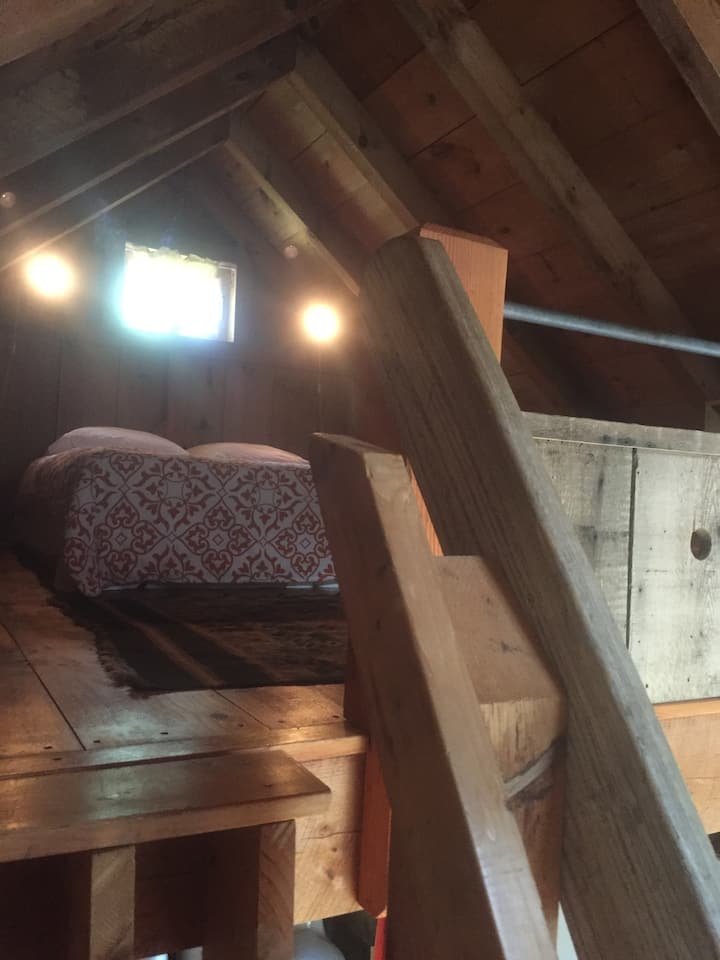 Podkrovie na spanie s manželskou posteľou/plnohodnotnou posteľou, strmé schody do podkrovnej spálne, môže stáť vzpriamene raz v strede podkrovia.