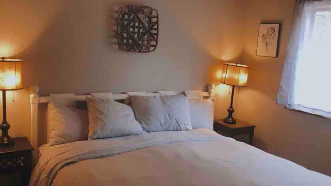 חדר שינה בקומה הראשית עם מיטת קינג סייז.