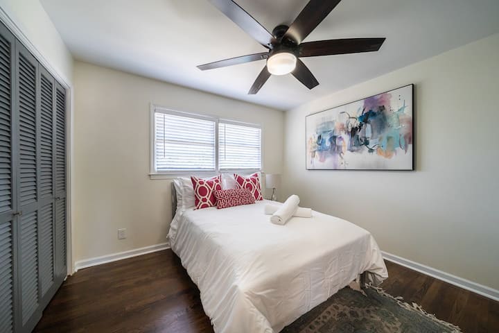 Spavaća soba za goste na katu s punim krevetom, komodom i Smart TV-om.