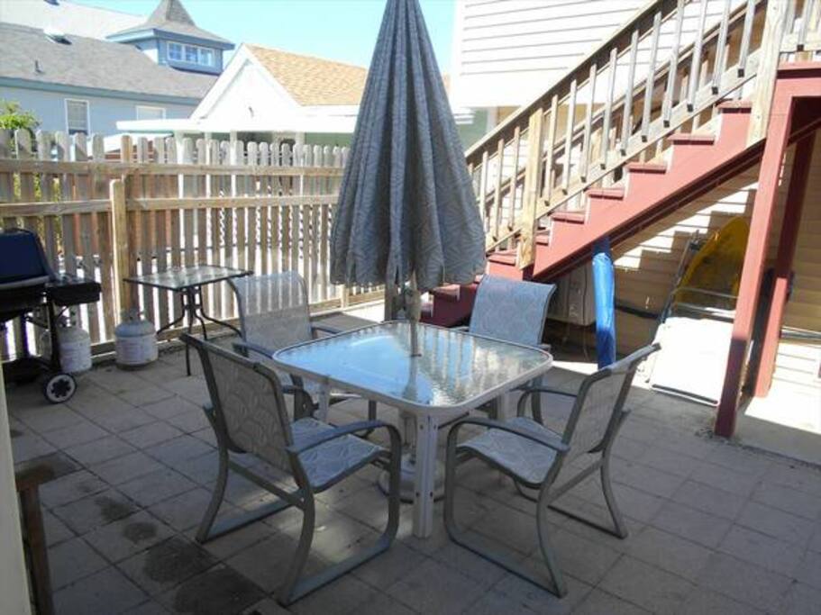 Outdoor seating area with a grill and outdoor shower.