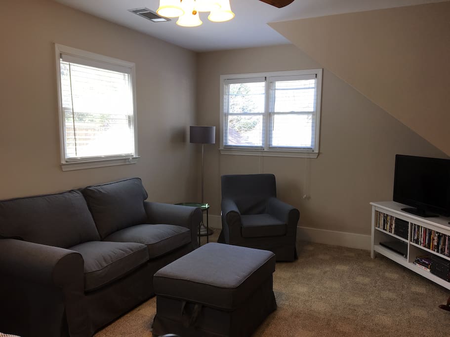 Living area with love seat, ottoman, arm chair and tv