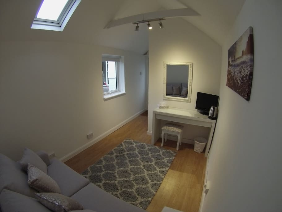 Main living space with sofa bed and dressing table