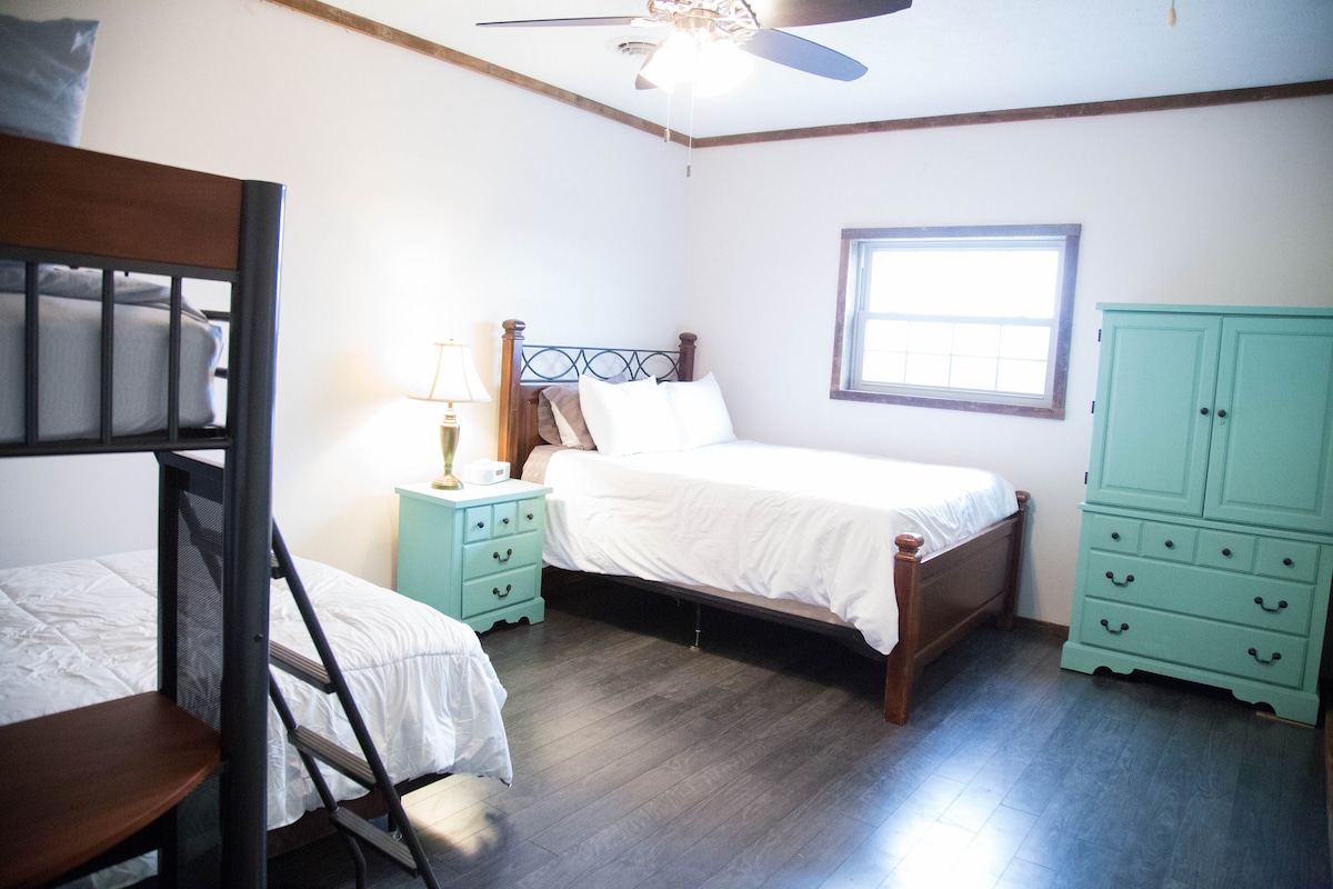 Chambre superposée avec lit double, lit jumeau et grand lit.  Chaise et bureau confortables. 