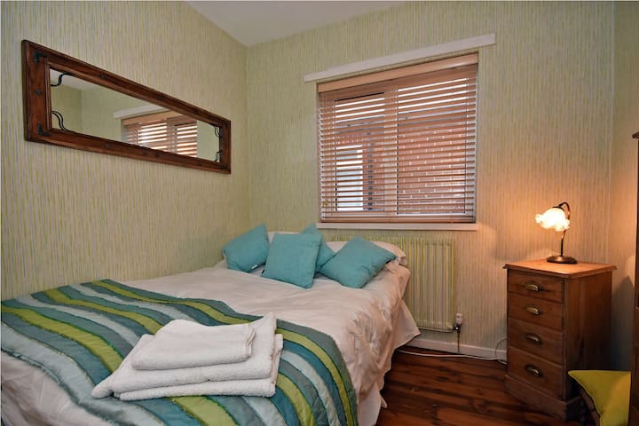 Segunda habitación con cama matrimonial con armario empotrado y cajones.